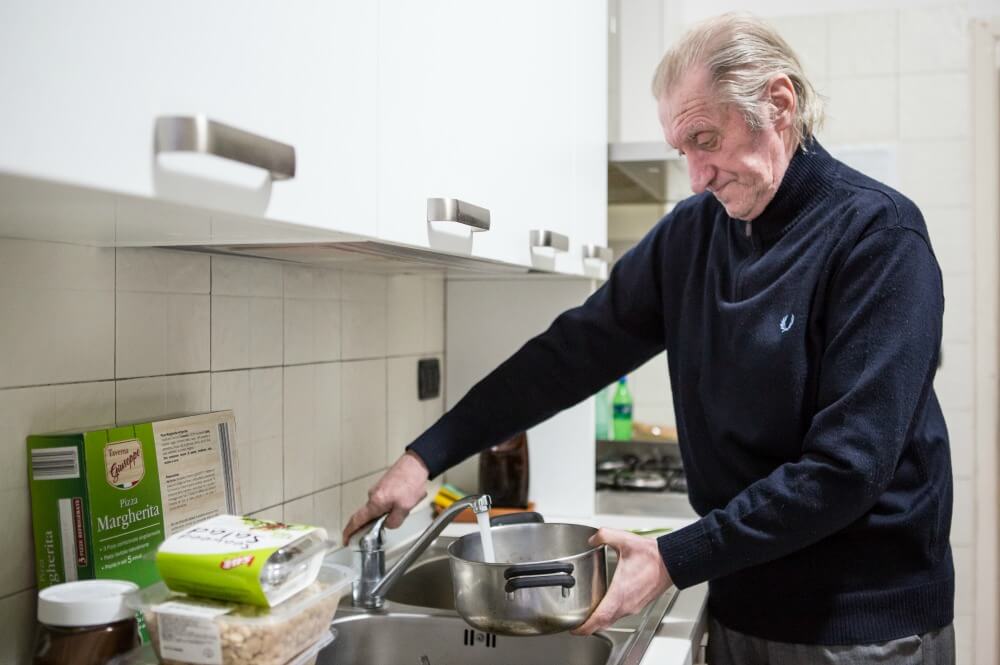 Tiziano cucina il pranzo nel cohousing di via Arsia